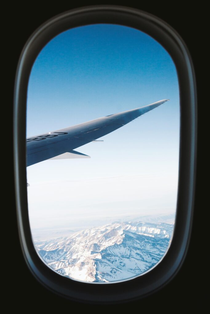 Stunning view of snow-capped mountains seen from an airplane window, showcasing the beauty of air travel.