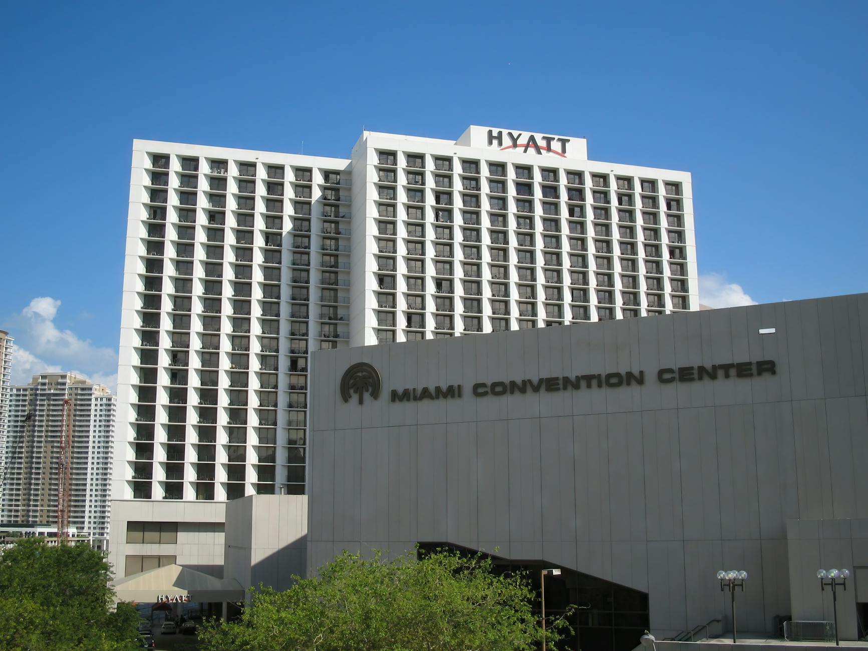 Exterior view of the Hyatt and Miami Convention Center under a clear blue sky.